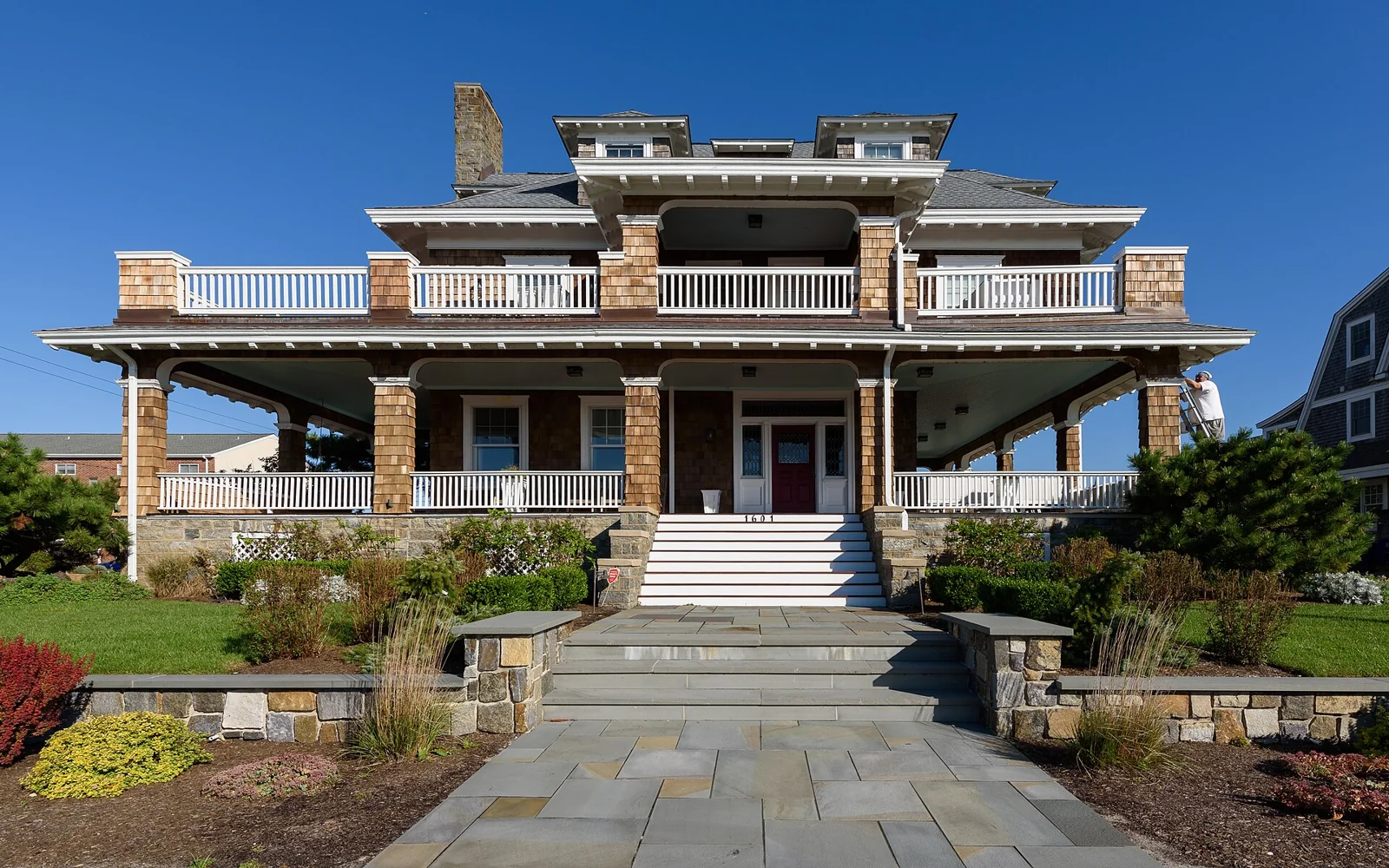 Large shingled house with a broad porch and stepped walkway in Cape May