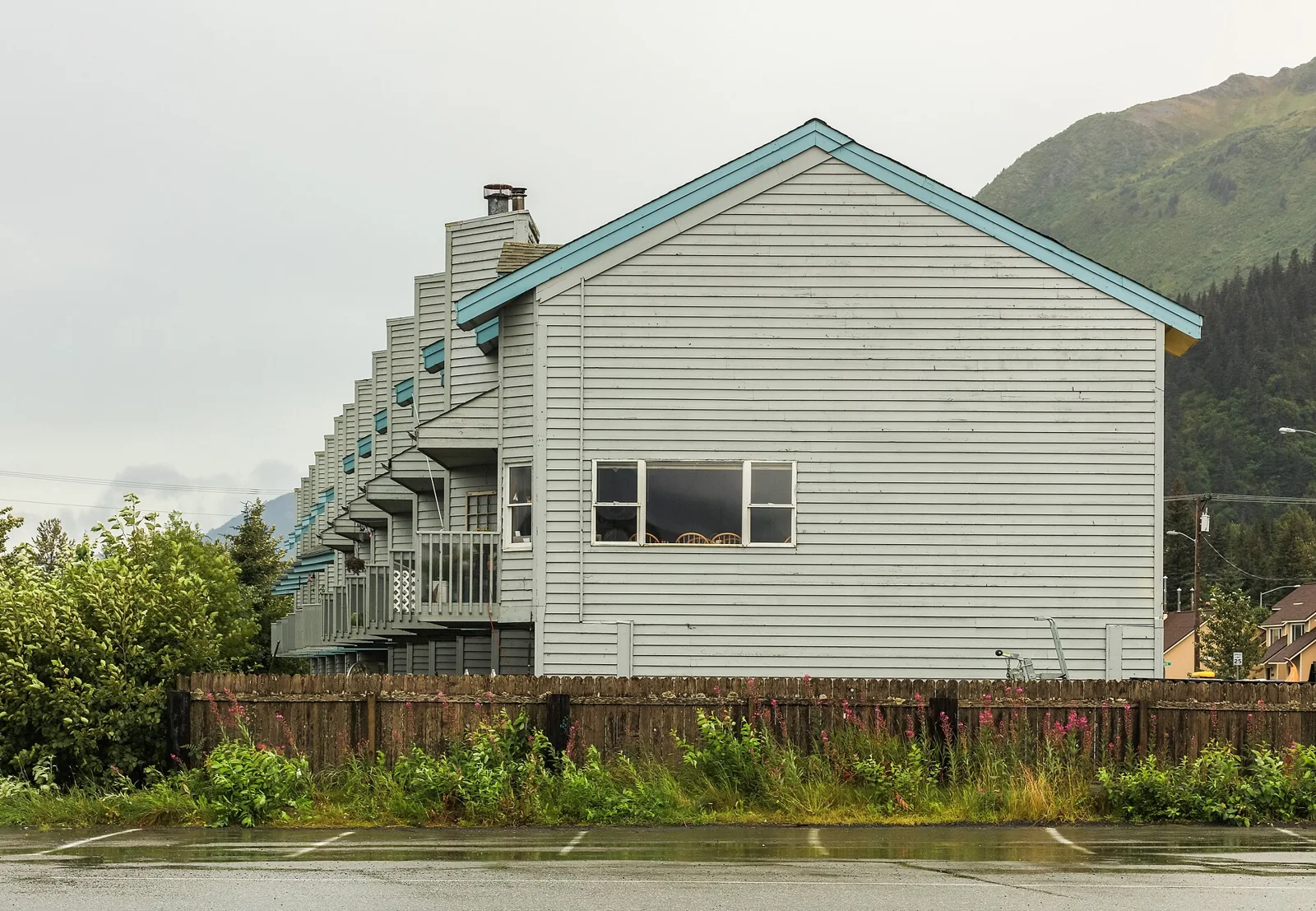 A row of light-colored townhouses below green mountains in Seward